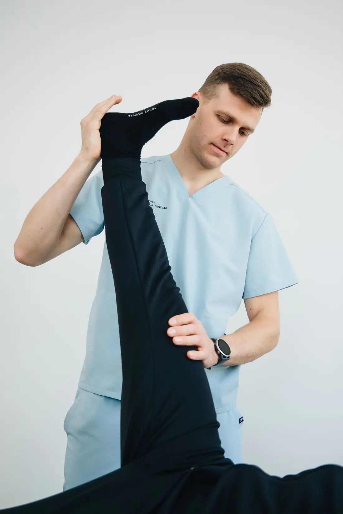 Clinician examining a patient's knee and lower limb