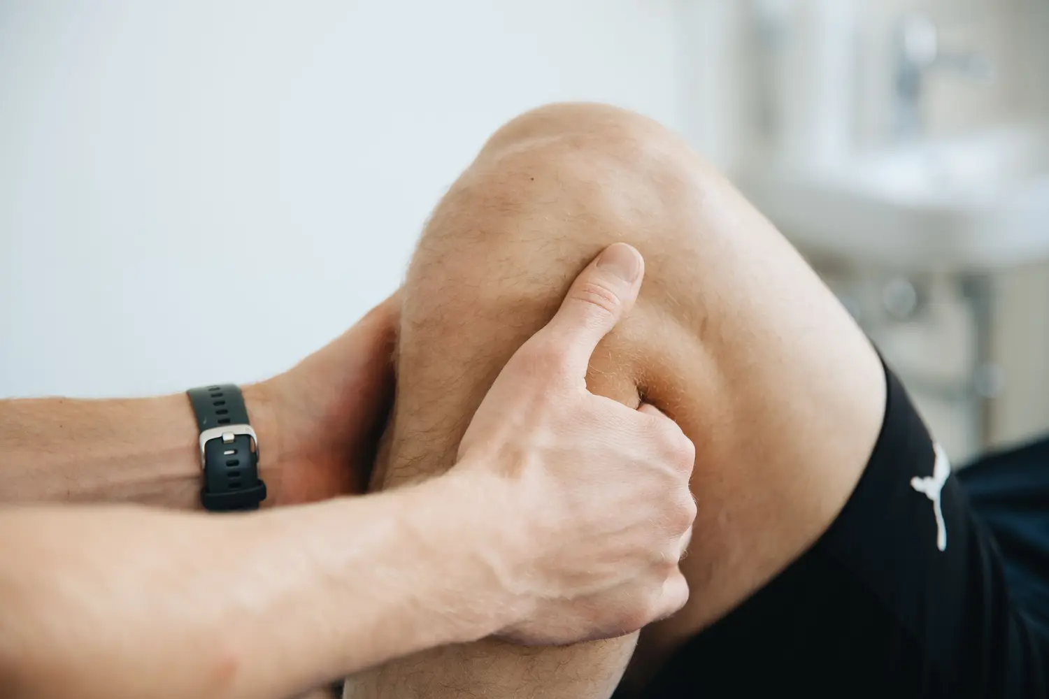Close-up clinical examination of a flexed knee